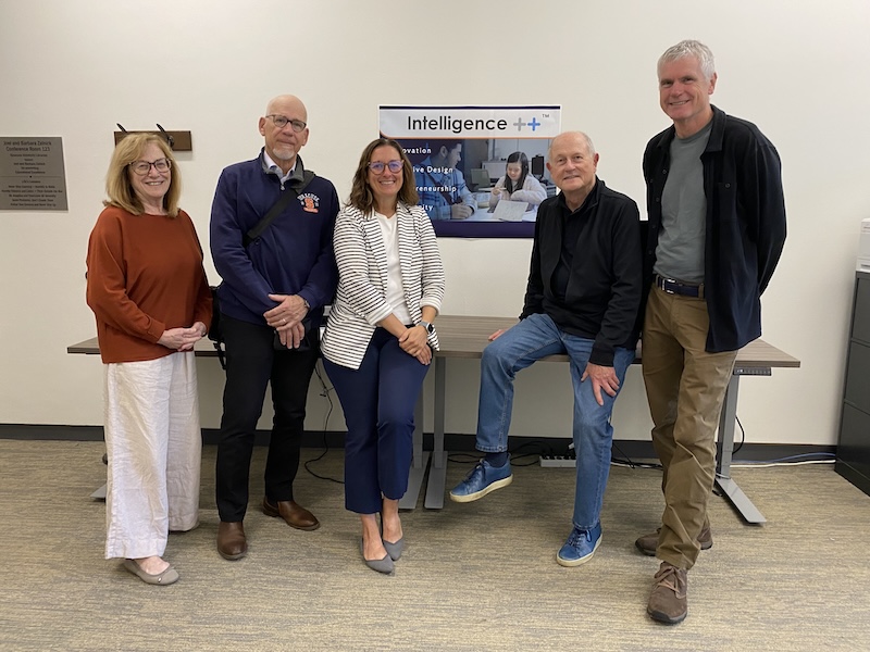A mixed group of men and women pose for a photo